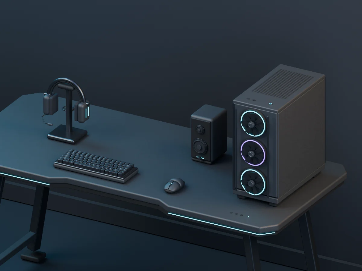 Gaming tower PC with illuminated fans, headset on its stand, mechanical keyboard, mouse and desktop speaker
